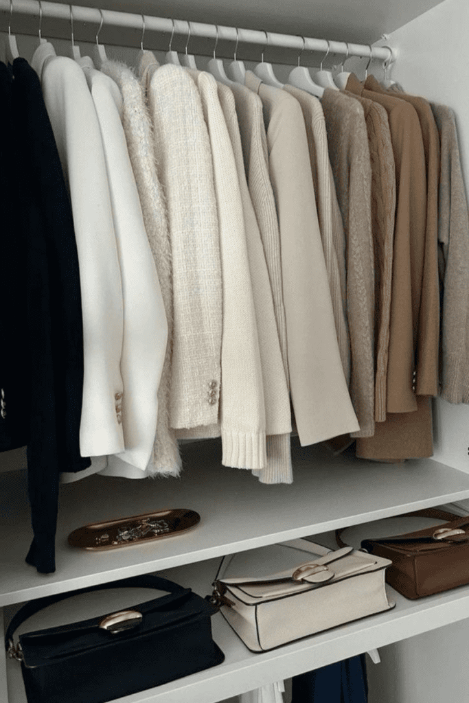 fall capsule wardrobe 2025 A curated capsule closet with neatly hung neutral-toned sweaters and bags in an organized wardrobe